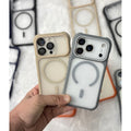A hand holds two MagSafe-compatible phone cases, one in beige and one in gray, in front of a white textured background with other blurred cases.